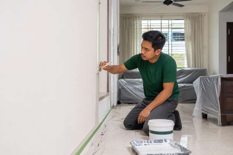 Juruteknik mengecat dinding rumah dengan ruang yang dilindungi